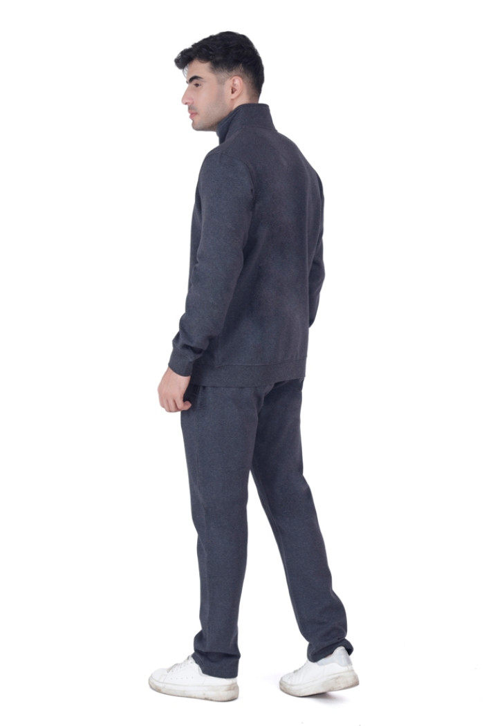A man in Coatsnmore’s Super Anthra tracksuit with a high collar, shown from the back while turning his head slightly to the side, wearing white sneakers and standing against a plain white background.